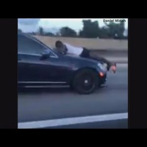 Man calls 911 whereas clinging to speeding automobile