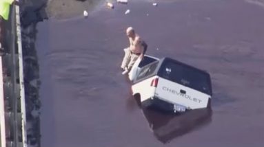 Man sits on car as it is miles swallowed by sinkhole